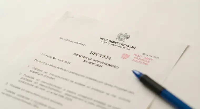 Analiza dokumentów podatkowych na biurku podczas sprawdzania, czy podatek od nieruchomości jest kosztem uzyskania przychodu przy wynajmie